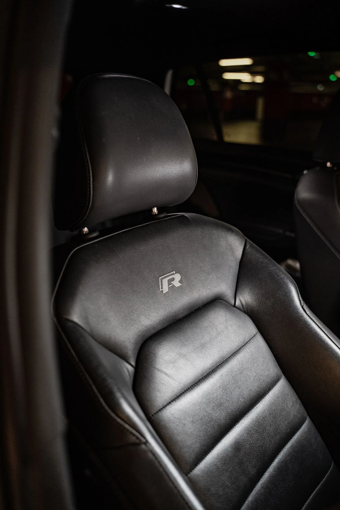 Black leather car seat with detailed stitching and textured upholstery